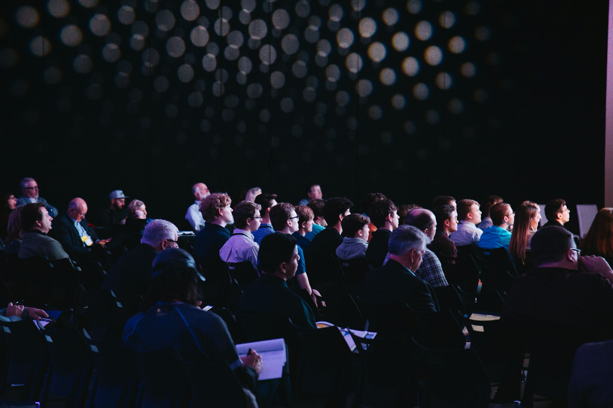A packed audience seated in rows at a technology conference
